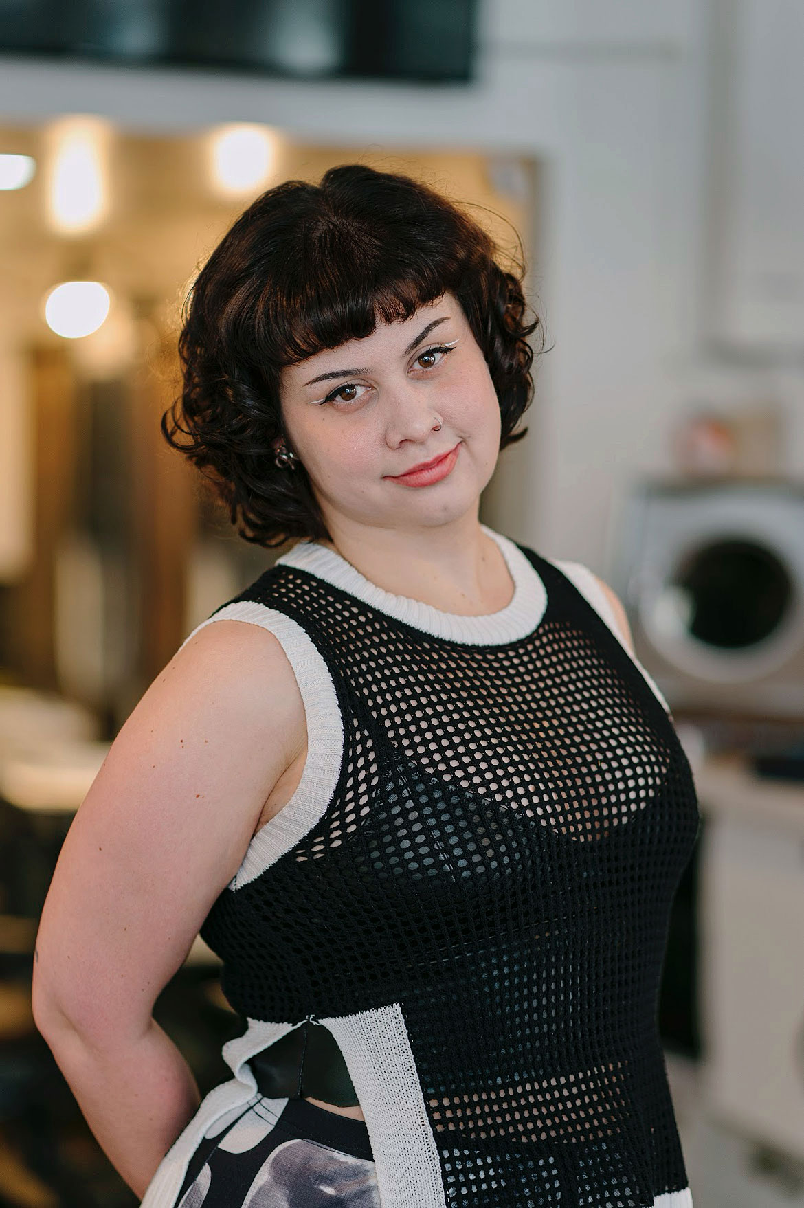Dani Caravalho, colorist at Kosa Salon San Francisco, wearing a black and white mesh top.